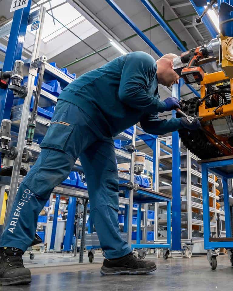 Factory worker of AriensCo EMEAA wearing their new turquise work wear inside their factory in Bühlertann, Germany