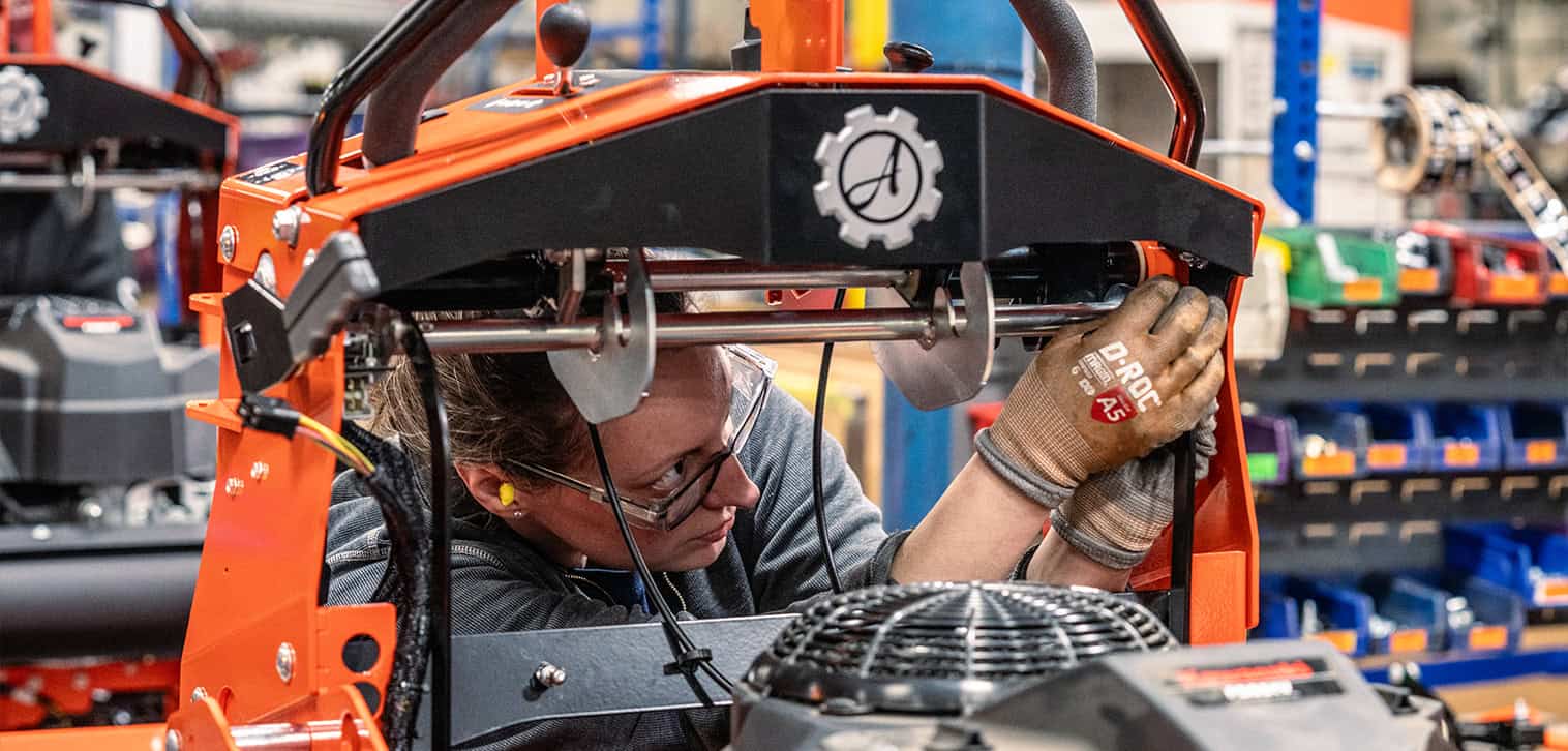 Ariens Warranty feature. Ariens worker assembles an Ariens Zero-Turn stand-on mower in the factory