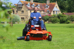 ariens ikon xd zero turn cutting grass on lawn in front of house