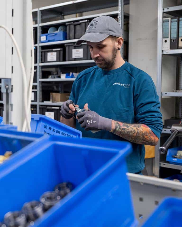 Factory worker of AriensCo EMEAA wearing their new turquise work wear inside their factory in Bühlertann, Germany