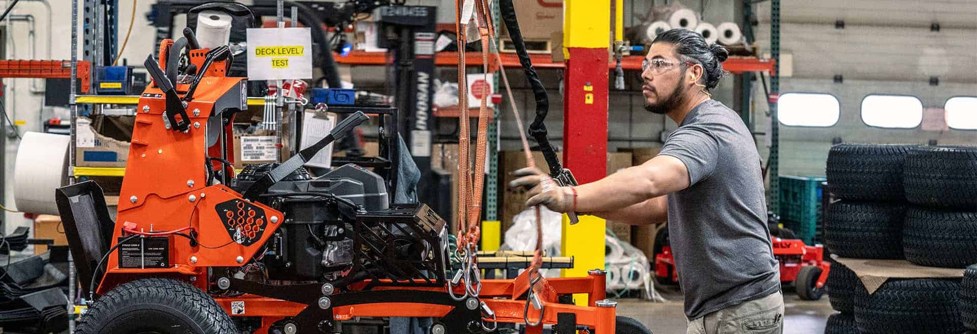 Ariens Warranty feature. Ariens worker assembles an Ariens Zero-Turn stand-on mower in the factory