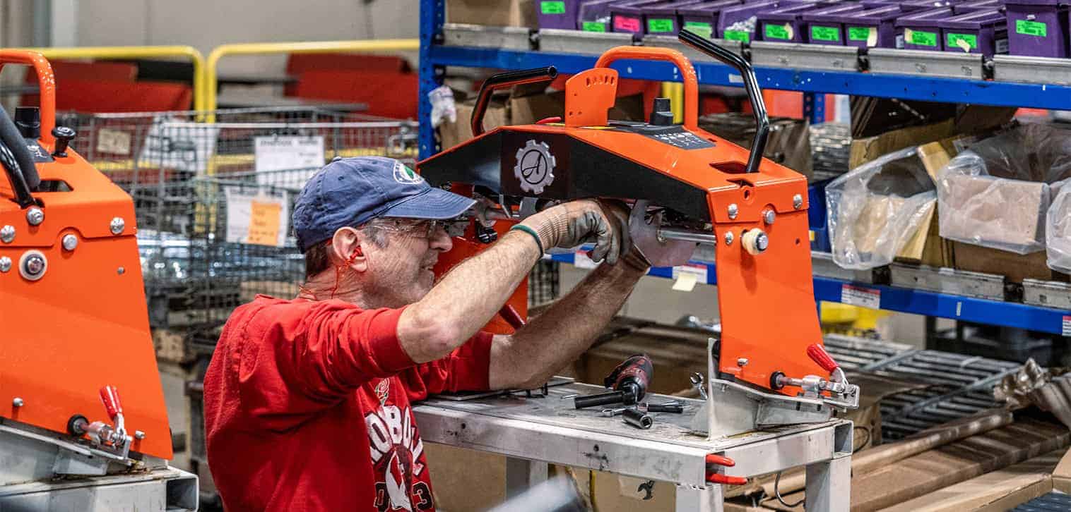 Ariens Warranty feature. Ariens worker assembles an Ariens Zero-Turn stand-on mower in the factory