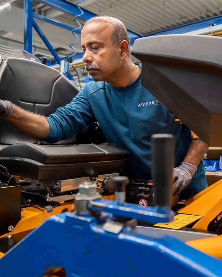 Factory worker of AriensCo EMEAA wearing their new turquise work wear inside their factory in Bühlertann, Germany