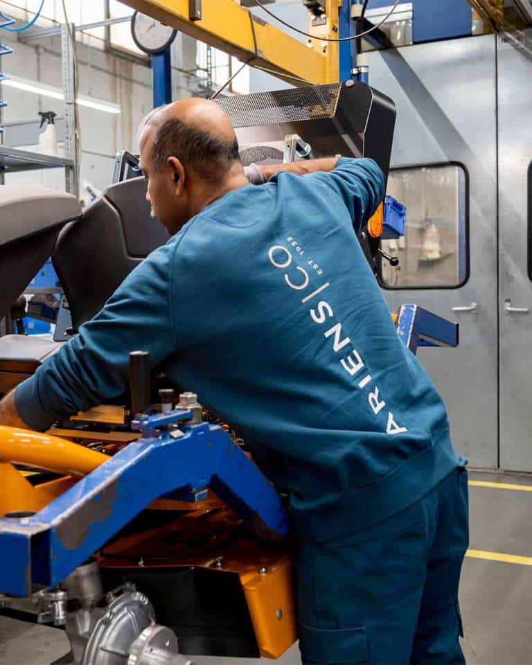 Factory worker of AriensCo EMEAA wearing their new turquise work wear inside their factory in Bühlertann, Germany