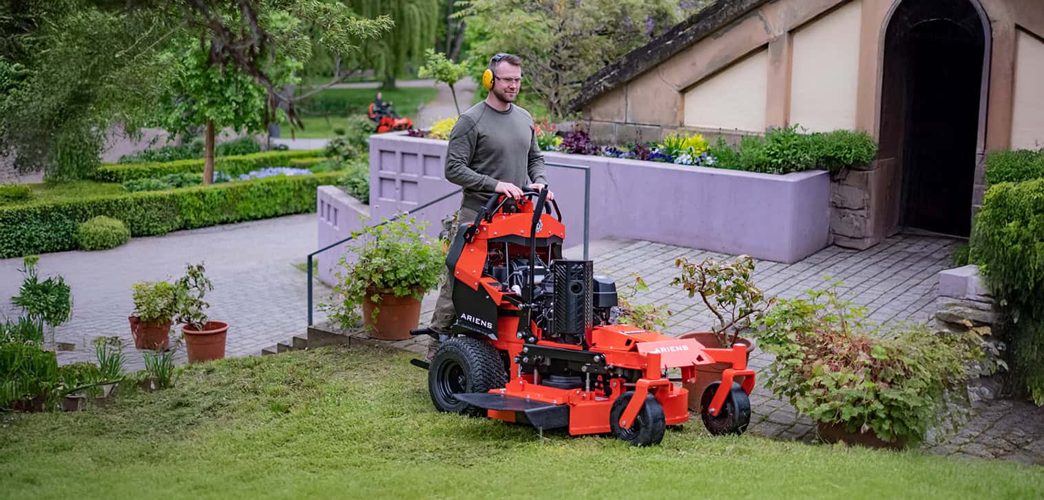 Ariens Zero-Turn Mower model ARROW, showcasing efficient mowing with zero-turn features. Happy young man is mowing the lawn with an Ariens Zero-Turn mower
