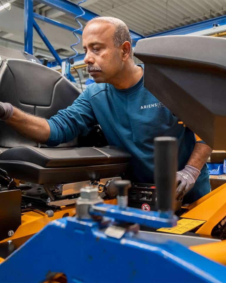 Factory worker of AriensCo EMEAA wearing their new turquise work wear inside their factory in Bühlertann, Germany