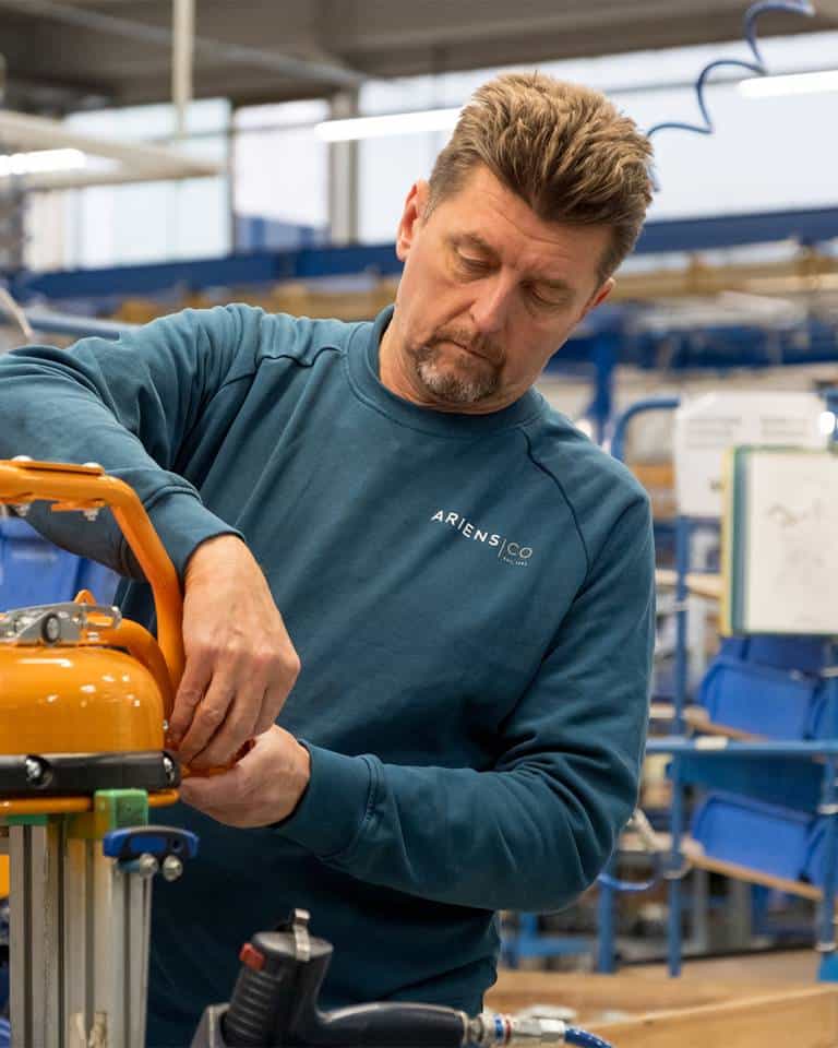 Factory worker of AriensCo EMEAA wearing their new turquise work wear inside their factory in Bühlertann, Germany