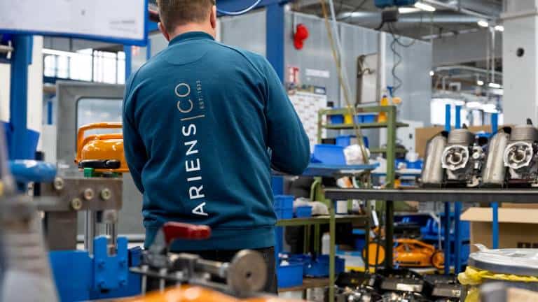 Factory worker of AriensCo EMEAA wearing their new turquise work wear inside their factory in Bühlertann, Germany